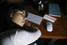 mujer joven dormida en el escritorio de trabajo