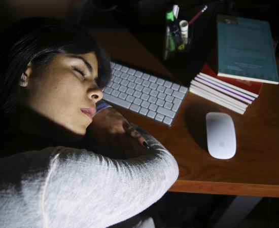 mujer joven dormida en el escritorio de trabajo